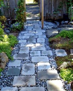 a stone path in the middle of a garden