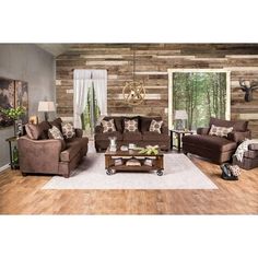 a living room with brown furniture and wood paneling on the walls, along with white rugs