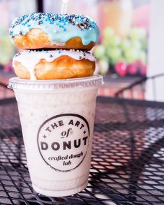 two donuts are stacked on top of each other in a cup with sprinkles