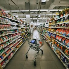 a shopping cart is in the aisle of a grocery store