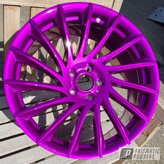 a purple wheel is sitting on a wooden bench