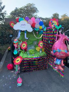 the trunk of a car decorated with balloons and decorations