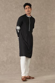 Black full sleeves kurta adorned with palm tree embroidery in dori and sequin work , concealed placket and pocket detail. Paired with ivory straight pant.
Components: 2
Pattern: Embroidery
Type Of Work: Palm Tree Embroidery In Dori, Sequin
Neckline: Mandarin Collar
Sleeve Type: Long
Fabric: Raw Silk
Color: Black
Other Details: 
Disclaimer: The actual print-placement and colour of the product may slightly vary slightly from the image shown.
Occasion: Sangeet - Aza Fashions Palm Tree Embroidery, Caribbean Fashion, Tree Embroidery, Lakme Fashion Week, Kurta With Pants, Versatile Outfits, Silk Embroidery, Full Sleeves, Trim Detail