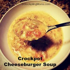 a white bowl filled with cheeseburger soup on top of a table next to a spoon