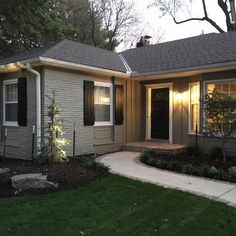 a small house with lights on the front door and windows in the side yard area