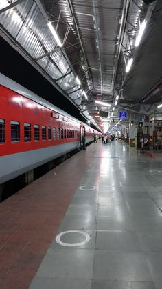 a red and white train parked in a station