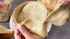 someone is holding up some tortilla on a plate next to other food items