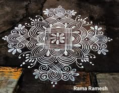 an intricate design is painted on the ground with white paint and watercolor pencils