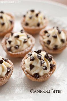 small desserts with white frosting and chocolate chips on top are arranged on a plate