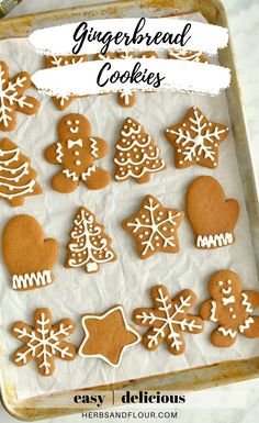 gingerbread cookies on a baking sheet with icing and snowflakes in the background