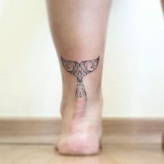 a woman's foot with a small tattoo on the top and bottom part of her leg