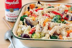 a casserole dish with broccoli, carrots and noodles