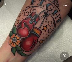 a tattoo with boxing gloves and flowers on it