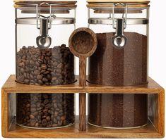 two glass jars filled with coffee beans on top of a wooden shelf next to each other