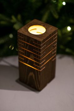 a wooden candle holder sitting on top of a table next to a christmas ornament