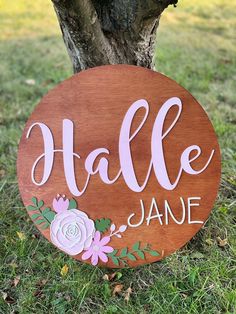 a wooden sign that says hale jane on it next to a tree in the grass