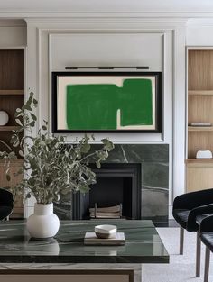 a living room filled with furniture and a painting on the wall over a fire place