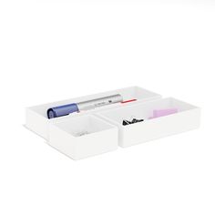 two white drawers with pens and markers in them