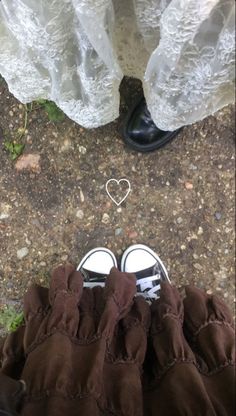 two people standing next to each other with their feet on the ground