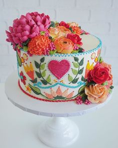 a decorated cake with flowers and hearts on it