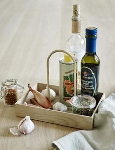 an assortment of spices and condiments in a wooden tray on a table top