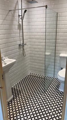 a white toilet sitting next to a walk in shower