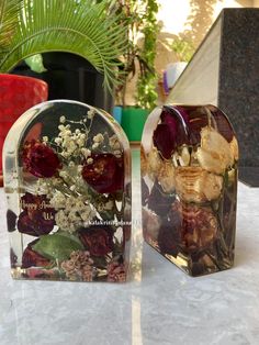 two clear vases with dried flowers in them