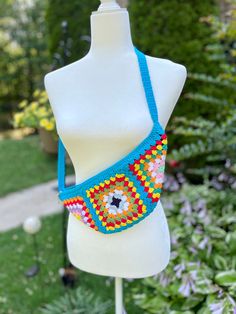 This handmade bum bag is perfect for those who love a boho and festival style. It is crafted with colorful granny squares, each crocheted with care and attention to detail. The vibrant squares stand out against a beautiful turquoise background, adding a pop of color to any outfit. The crochet free bag is designed to be worn as a sling bag, providing both style and functionality. It offers a spacious compartment to keep your essentials organized and easily accessible.  Whether you're heading to a music festival, exploring a new city, or simply running errands, this fanny pack is a convenient and trendy accessory. Made with love and attention to detail, this crochet chest bag is a one-of-a-kind piece that adds a touch of creativity and uniqueness to your style. It's not just a bag; it's a st Bohemian Belt Bag For Everyday Use, Blue Bohemian Crochet Shoulder Bag, Blue Festival Shoulder Bag With Adjustable Strap, Blue Shoulder Bag With Adjustable Strap For Festival, Summer Festival Crochet Bag With Adjustable Strap, Blue Bohemian Crochet Bag For Festival, Handmade Turquoise Bags For Summer, Handmade Turquoise Summer Bag, Multicolor Belt Bag For Everyday Summer Use