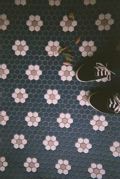 a person standing on a tiled floor with their feet propped up against the ground,