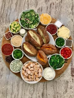 a wooden platter filled with different types of food on top of a marble counter