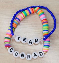 two bracelets with words that spell out team conradi on them sitting on a table