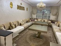 a living room filled with lots of furniture and a chandelier hanging from the ceiling