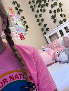 a girl with braids in her hair wearing a pink shirt