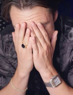 a man covering his face with his hands