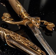 an elaborate gold and silver knife on a black surface