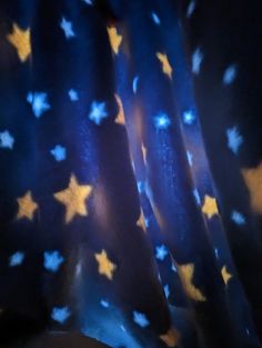 blue and yellow stars are on the curtain in front of a black background with white dots