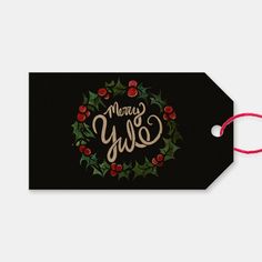 a black christmas gift tag with holly and berries