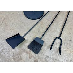 three brooms and two brushes laying on the floor