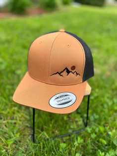 Custom embroidered mountain range with sunset design. Design is embroidered on the cap directly. Color thread may be changed to meet your needs.  Hats are high quality Richardson Snap back caps. Variety of cap colors to choose from. If you do not see the color you want, please send me a message and we can work out a custom order. Embroidered Hats Baseball Caps Men, Felt Burning, Custom Snapbacks, Burning Hats, Fall Cap, Richardson Hats, Adventure Hat, Mountain Hat, Mens Hats Baseball