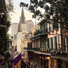 an image of people walking down the street in front of buildings with steeple tops