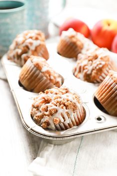 muffins with icing and apples in the background