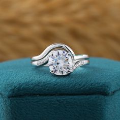 a diamond ring on top of a blue cushion