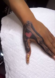 a person's hand with a tattoo on it and a heart in the middle