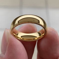 a person holding a gold ring in their hand