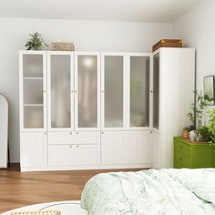 a bedroom with white cabinets and green furniture