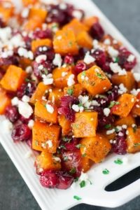 sweet potato salad with cranberries and feta cheese on a white platter