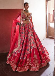 This exquisite banarasi lehenga, inspired by the elegance of jharokhas, is beautifully paired with a coral plunging V-neck sheeted blouse and a flowing organza dupatta. Delicately highlighted with cut mirrors and pearls, the ensemble radiates sophistication and charm. A stylish belt cinches the waist, enhancing the silhouette and completing this stunning look with a perfect blend of tradition and contemporary flair. Traditional Drape Dola Silk Choli With Meenakari, Silk Lehenga With Meenakari For Designer Wear, Designer Meenakari Chanderi Lehenga, Meenakari Raw Silk Choli For Saree, Festive Meenakari Choli In Raw Silk, Navratri Meenakari Choli In Raw Silk, Silk Meenakari Choli For Reception, Festive Raw Silk Lehenga With Meenakari Detail, Festive Raw Silk Lehenga With Meenakari