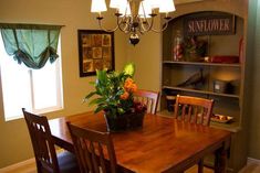 a dining room table with chairs and a potted plant