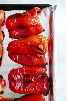 red peppers are lined up on a sheet of tin foil, ready to be cooked