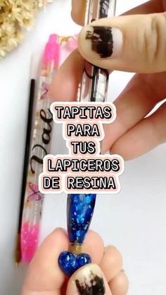 a person holding a pen with the words taptass para tus lapiceros de resina